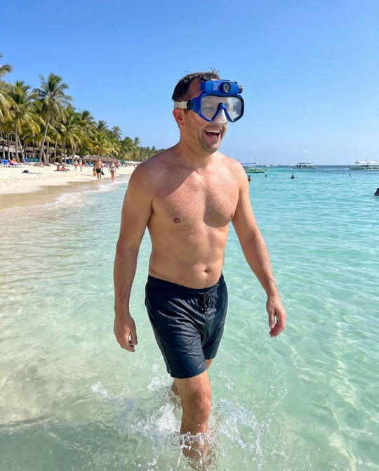 Man wading out of the sea wearing the blue mask on his forehead