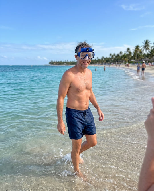 Man wading out of the water wearing the blue mask