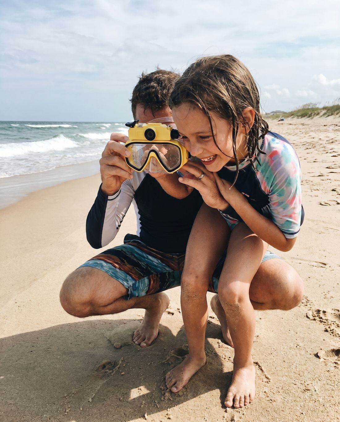 Parent fitting the mask on their child at the pool
