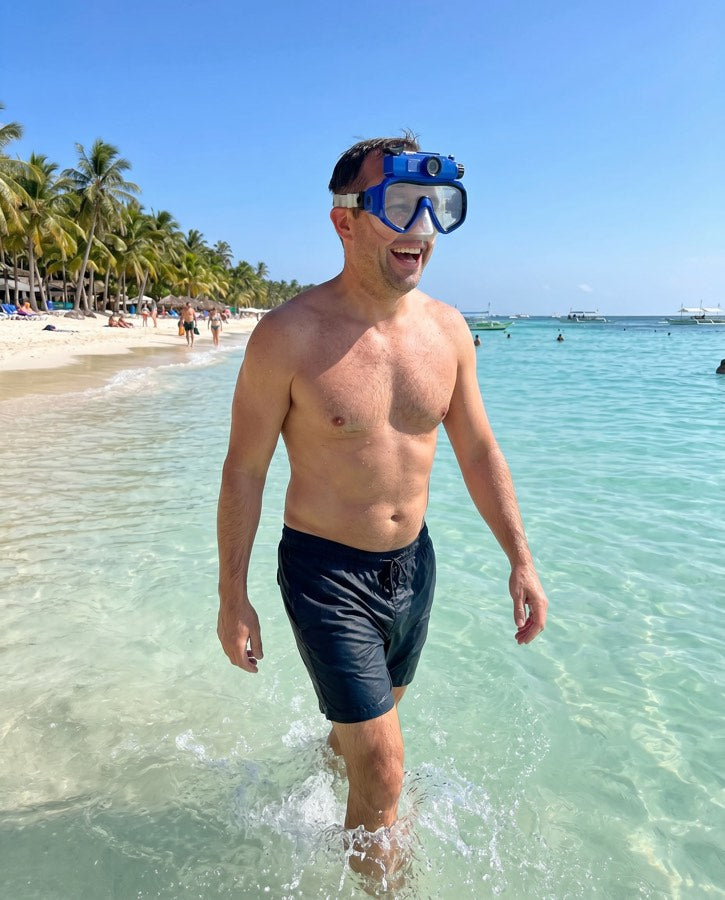 Man wading out of the sea wearing the blue mask on his forehead