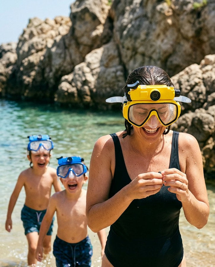 Woman with the yellow mask and two kids in blue masks at a rocky beach