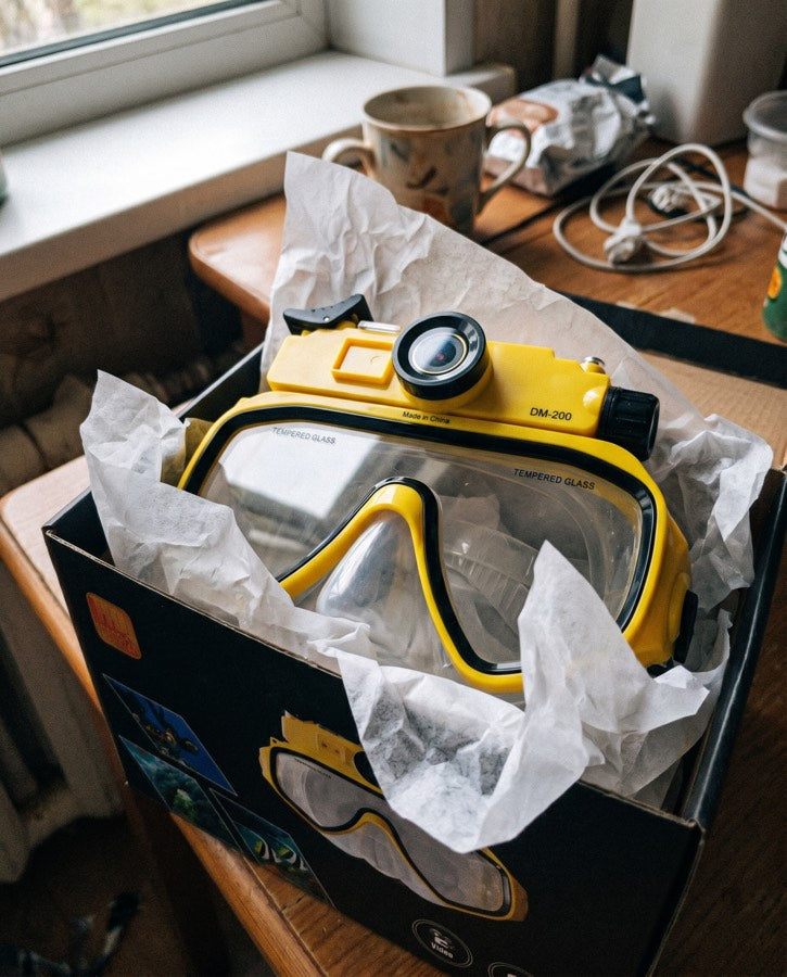 Yellow mask resting in its box by a kitchen window