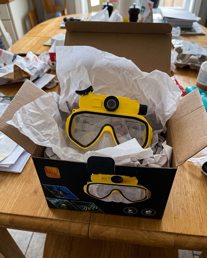 Yellow mask in its box on a wooden table