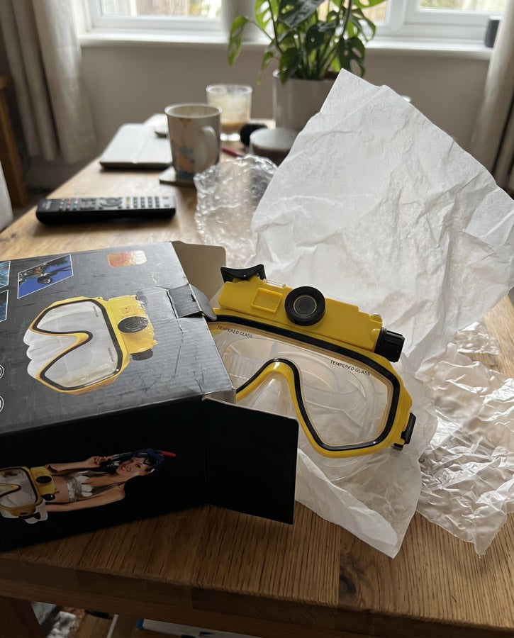 Yellow mask unboxed on a table beside a plant