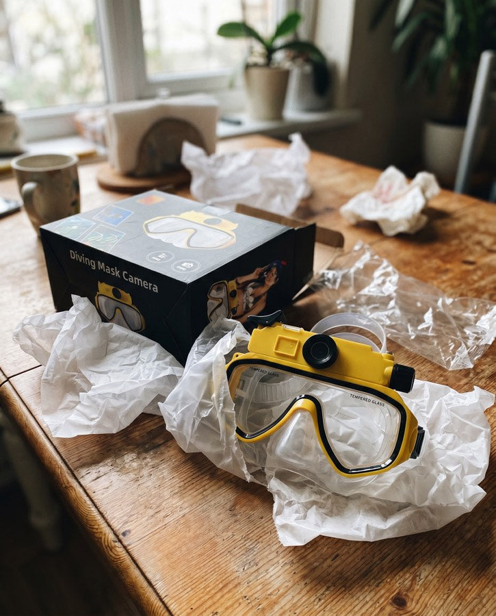 Yellow mask out of its box on a wooden table