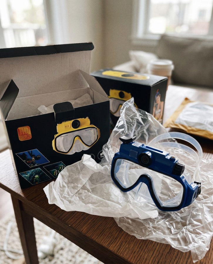 A yellow mask in its box beside a blue mask
