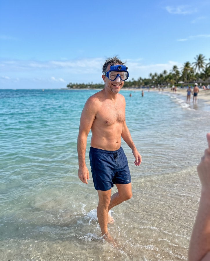 Man wading out of the water wearing the blue mask